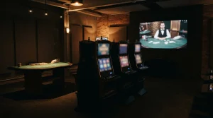 Unbranded slot cabinet silhouettes beside a blackjack table and an abstract live-dealer screen in a quiet studio setting